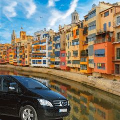 Banner de nuestra visita "Girona en un dia": vista de Girona y minivan Mercedes